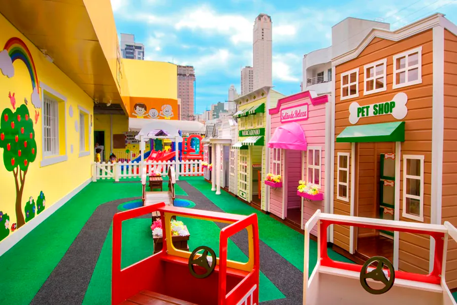 Brinquedoteca com arquitetura infantil inspirada em uma minicidade colorida