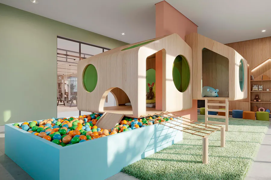Espaço infantil de condomínio com piscina de bolinhas e brinquedo arquitetônico