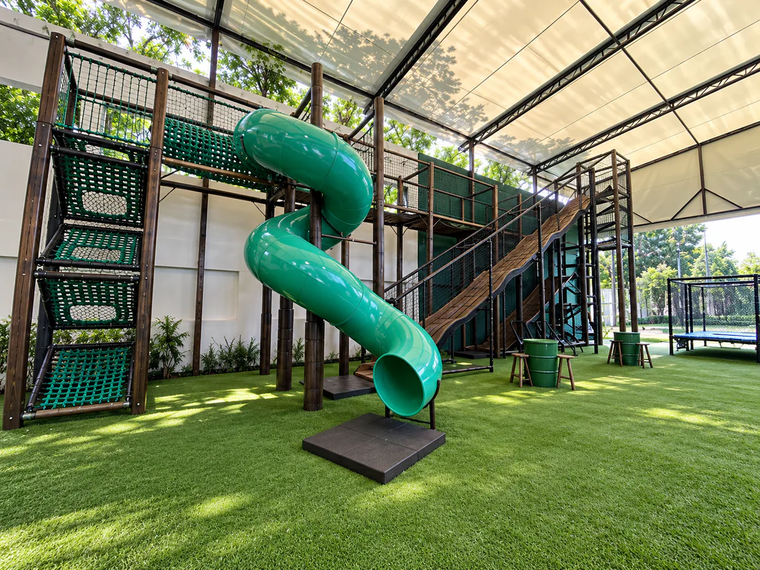 Parque infantil institucional com circuito elevado, escorregador e áreas de atividade